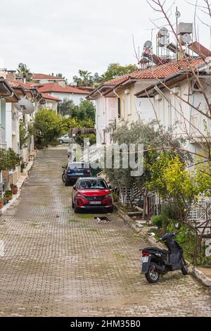 Side, Turchia -20 gennaio 2022: Strada della città con diverse case basse, auto e parcheggio per motociclette Foto Stock