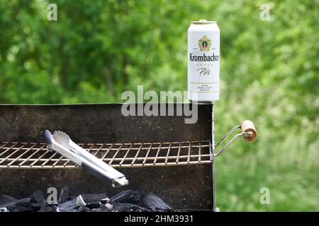 Stoccarda, Germania - 04 giugno 2021: La birra della birreria Krombacher si trova all'angolo destro di una griglia. Le pinze in acciaio inox sono sporche. Gowi Foto Stock