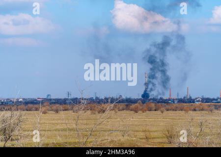 Fumo da un incendio nella distanza dietro il campo Foto Stock