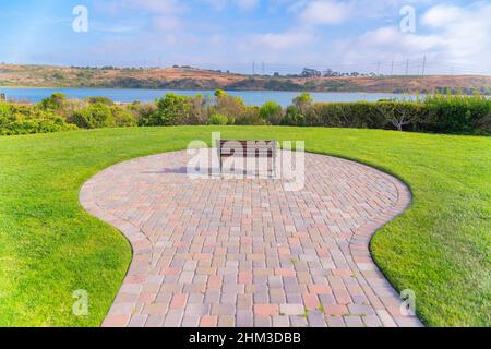 Panchina Lone di fronte alla vista della Laguna di Agua Hedionda a Carlsbad, San Diego, California Foto Stock