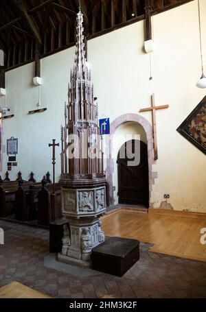 Fonte battesimale in pietra medievale con un'alta e elaborata copertura in legno del 1930, chiesa di Pakenham, Suffolk, Inghilterra, Regno Unito Foto Stock