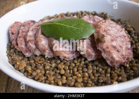cotechino affettato con lenticchie in una ciotola di ceramica Foto Stock