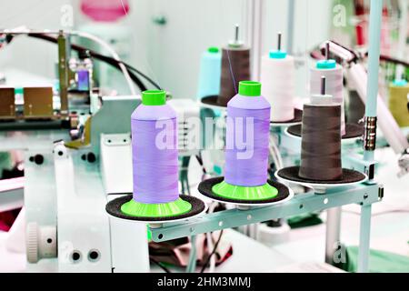 Laboratorio di cucitura con fili e macchine da cucire elettriche Foto Stock