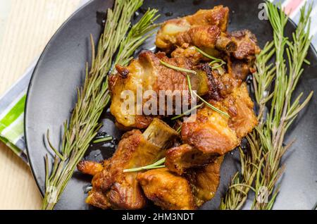 costolette di maiale arrosto con rosmarino su un piatto Foto Stock