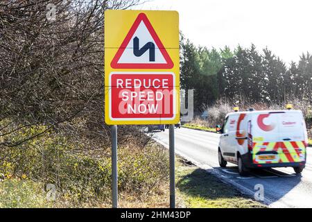 Ridurre ora la velocità, ridurre ora la velocità segnaletica stradale, segnaletica stradale, segnaletica stradale, ridurre ora la velocità, ridurre la velocità, rallenta, strada tortuosa davanti, curve, curve Foto Stock