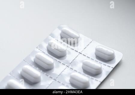 Nuova confezione blister inutilizzata con pillole su sfondo bianco, sfondo medico o farmaceutico concettuale con spazio di copia per il testo Foto Stock