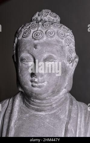 Statua del Buddha di Siddharha Gautama in pietra grigia come decorazione interna, vista ravvicinata del ritratto Foto Stock