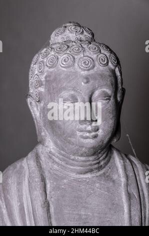 Statua del Buddha di Siddharha Gautama in pietra grigia come decorazione interna, vista ravvicinata del ritratto Foto Stock