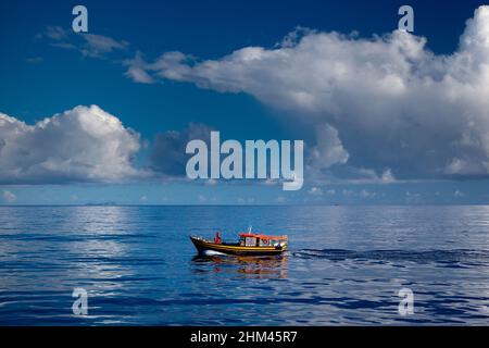 Un piccolo peschereccio che naviga in perfette condizioni glassose nell'arcipelago delle Seychelles tra le isole Mahe e la Digue. Foto Stock