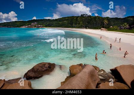I turisti che nuotano a Grand Anse Beach sull'isola la Digue, Seychelles. Foto Stock