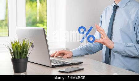 La mano dell'uomo d'affari prende un'icona di simbolo di percentuale. Tasso di interesse finanziario e ipoteca concetto di tassi Foto Stock