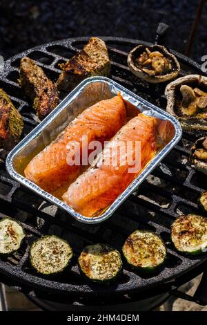 carne di vitello, salmone e zucchine su griglia da giardino con carbone Foto Stock