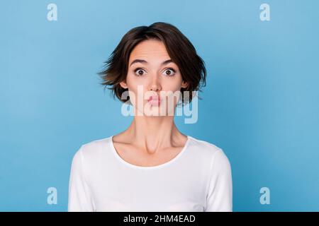 Foto di dolce bella giovane donna vestita camicia bianca che ti mandano bacio isolato sfondo di colore blu Foto Stock