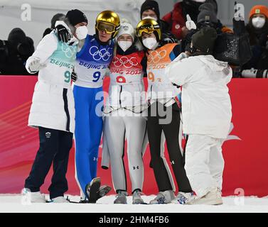 Zhangjiakou, Cina. 07th Feb 2022. Olimpiadi, salto con gli sci, squadra mista, collina normale, al National Ski Jumping Centre. Al primo posto Timi Zajc, Peter Prevc, Nika Kriznar e Ursa Bogataj (l-r) dalla Slovenia celebrano insieme dopo la partita. Credit: Angelika Warmuth/dpa/Alamy Live News Foto Stock