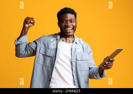 Felice americano ragazzo africano condividere il successo, utilizzando pad Foto Stock