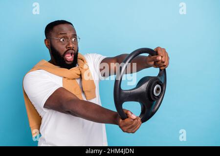 Foto di pazzo tizio tenere volante incidente concetto indossare bianco t-shirt jumper front-tie isolato blu sfondo di colore Foto Stock