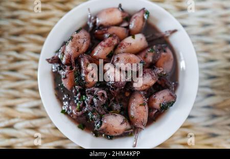 Prezzemolo e calamari all'aglio scottati. Foto Stock