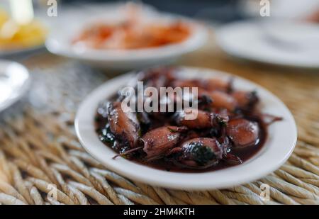 Prezzemolo e calamari all'aglio scottati. Foto Stock