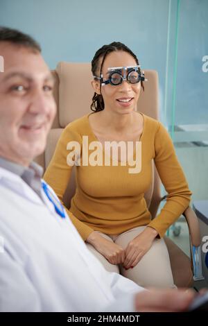 Donna sorridente nelle cornici di prova felice di poter leggere tutte le lettere sulla tabella di prova Foto Stock