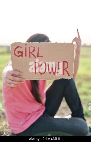 Donna che tiene un cartone riciclato con l'iscrizione girl power. Concetto di femminismo. Foto Stock