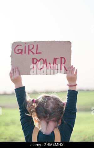 Ragazza che tiene un cartone riciclato con il potere della ragazza di iscrizione. Concetto di femminismo. Foto Stock