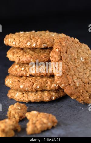 Biscotti fatti in casa con crunchy texture biologica senza glutine di avena impilati in un mucchio su sfondo scuro Foto Stock