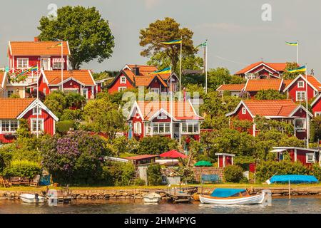 Tipiche case in legno rosso svedese con barche nella città di Karlskrona Foto Stock