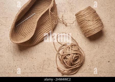 Borsa o cestino per maglieria a crochet in iuta. Concetto estivo di hobby piatto. Foto Stock