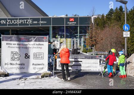 Numerose persone sono in attesa di ingresso alla funivia per la montagna Zugspitze nelle Alpi. Devono mostrare il loro certificato di vaccinazione Covid Foto Stock