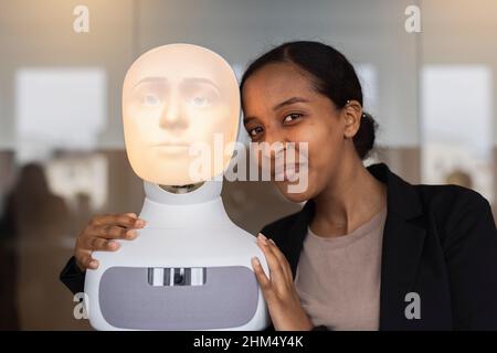 Ritratto di giovane donna con assistente vocale robot Foto Stock