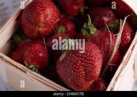 fragola fresca in un piccolo cestino di legno. Primo piano Makro Foto Stock