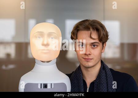 Ritratto del giovane con assistente vocale robot Foto Stock
