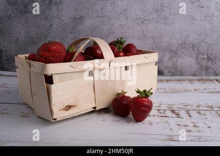 fragola fresca in un piccolo cestino di legno. Fotografato dal lato Foto Stock