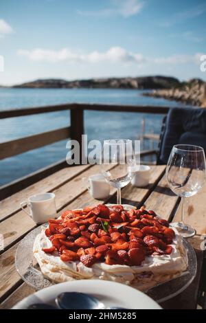 Meringa con fragole sul tavolo Foto Stock