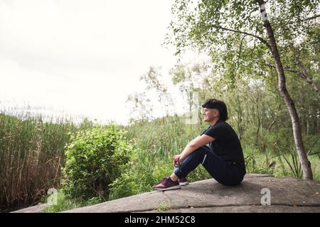 Giovane donna che si rilassa sul lago Foto Stock