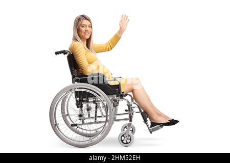 Ripresa a tutta lunghezza di una donna incinta seduta su sedia a rotelle e che agita isolata su sfondo bianco Foto Stock