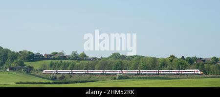 Treno in livrea LNER che attraversa i terreni agricoli aperti della contea di Durham Foto Stock