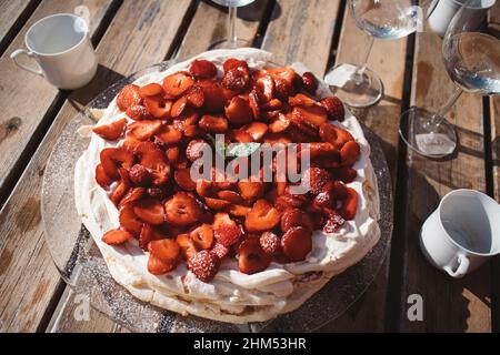 Meringa con fragole sul tavolo Foto Stock