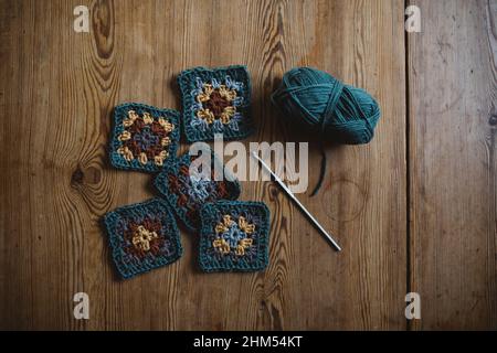 Quadrati a crochet su sfondo di legno Foto Stock