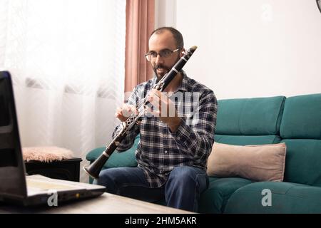 Clarinetista che dà online clarinetto classe con il portatile da ho Foto Stock