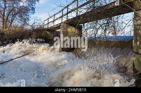 vecchio ponte su uno stramazzo su un piccolo fiume Foto Stock