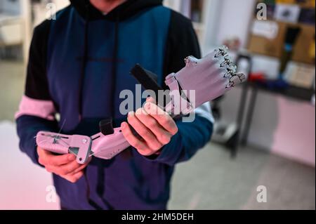 Uomo in possesso di una protesi del braccio in plastica stampata nel 3D a Zaragoza Makerspace Foto Stock