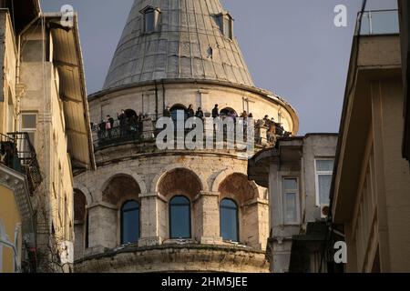 Istanbul, Turchia - 29 dicembre 2022 : turisti con maschere mediche alla Torre Galata. Stanno guardando il paesaggio di Istanbul al tramonto. Foto Stock