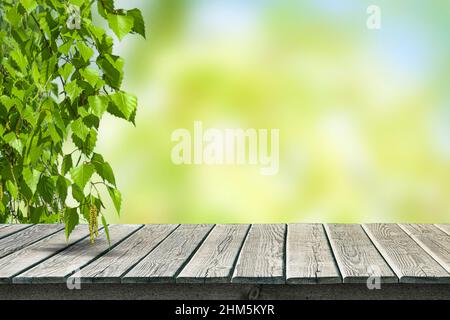 Tavolo vuoto in legno vecchio per esposizione prodotto su sfondo sfocato giardino e stagione estiva. Foto Stock