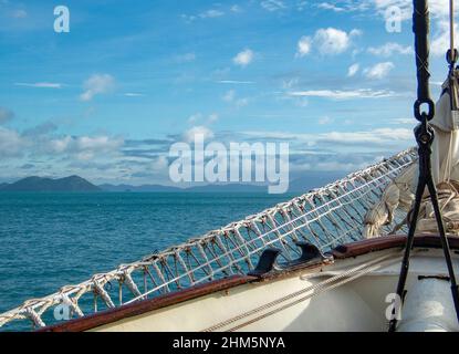 Vista verso l'orizzonte nelle Isole Whitsunday, Australia da una nave alta con archi e armamenti in primo piano Foto Stock