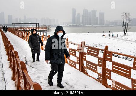 Wuhan, Cina. 07th Feb 2022. La gente cammina nel parco Jiangtan durante una nevicata a Hubei.Wuhan ha inaugurato la prima nevicata del nuovo anno cinese. (Foto di Ren Yong/SOPA Images/Sipa USA) Credit: Sipa USA/Alamy Live News Foto Stock