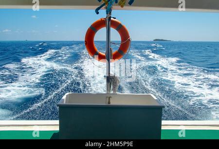 Cintura di salvataggio in barca liveaboard nelle Maldive in una giornata di sole guardando verso la poppa e l'orizzonte Foto Stock