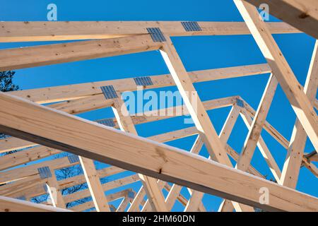 Capriate in legno per tetto su un nuovo progetto di costruzione casa con cielo blu. Foto Stock