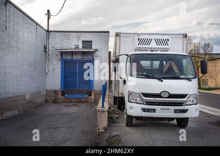 Furgone di consegna di fronte ad un piccolo edificio aziendale Foto Stock