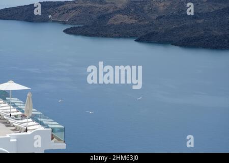 Santorini, Grecia - 7 maggio 2021 : una piscina con lettini da mare in un hotel di lusso che si affaccia sul mar egeo in Santorini Grecia Foto Stock